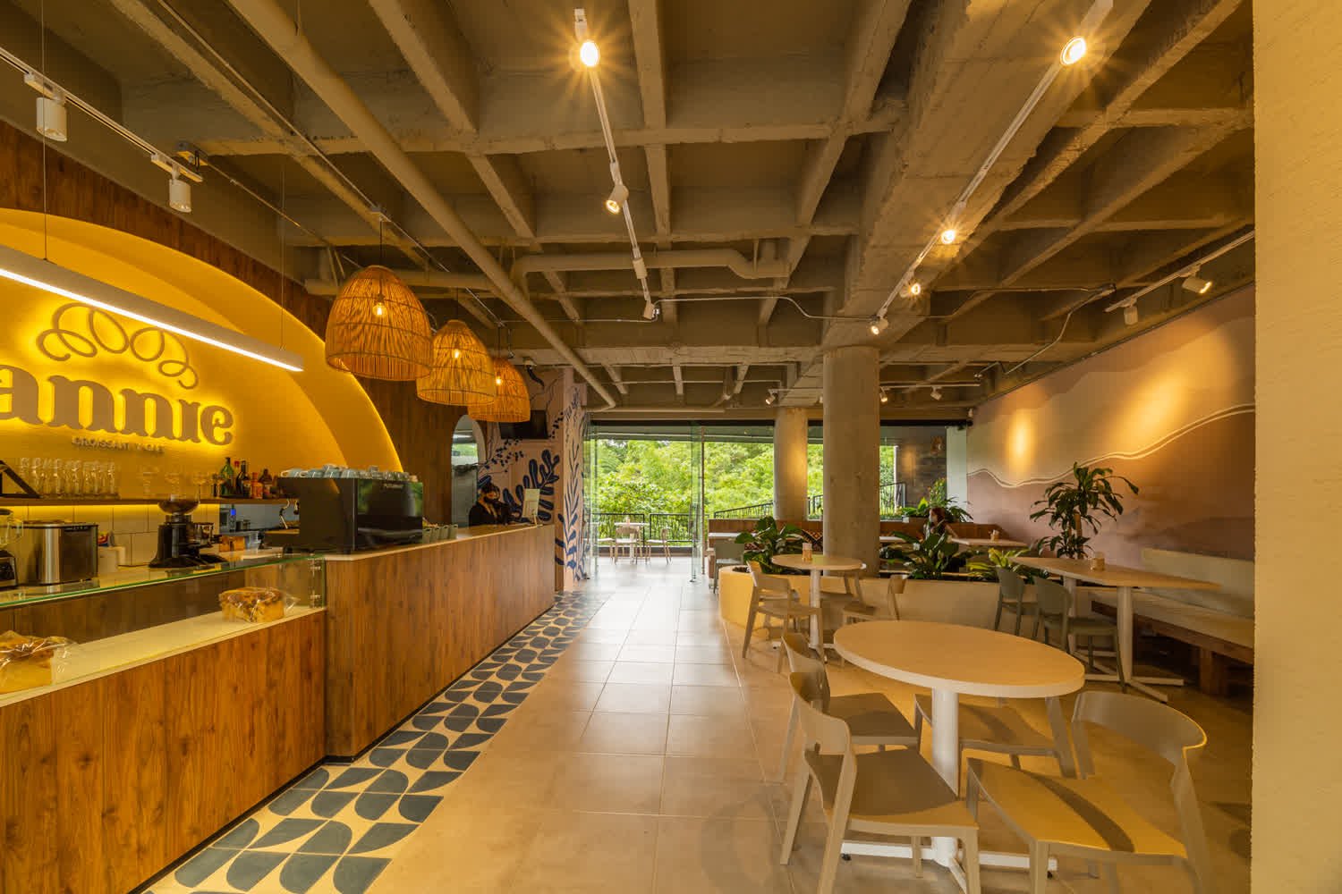 Interior de panadería con barra en fuga y salón al fondo